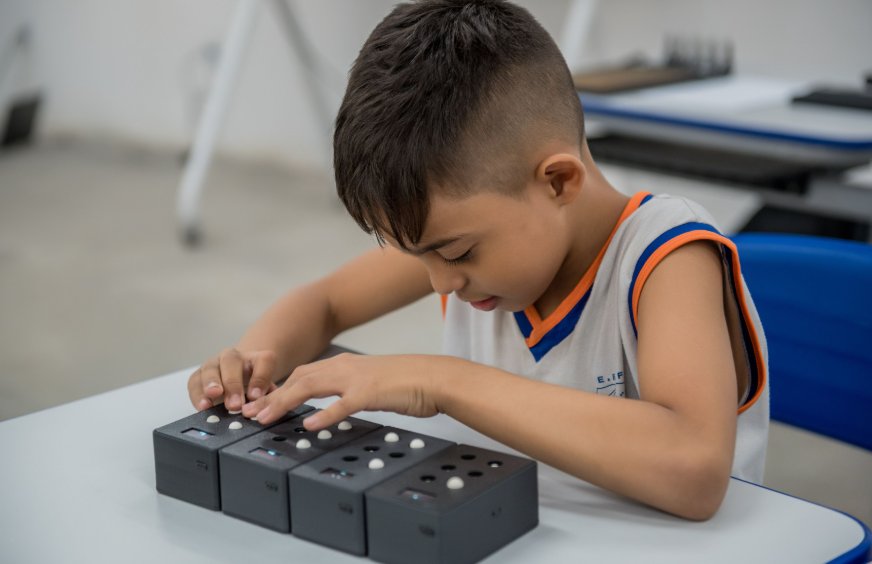 Criança utilizando o EdukaBraille em sala de aula